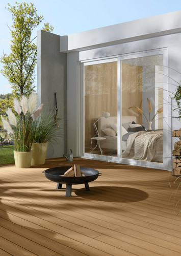 Gemütliche Terrasse mit Terrasse, Lounge-Sessel und Feuerstelle vor modernem Haus.